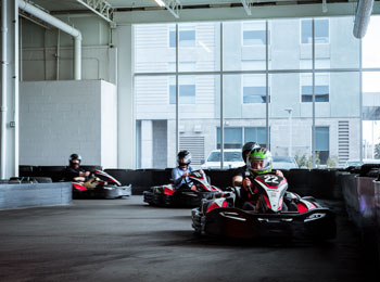 Adults and children racing on the indoor circuit
