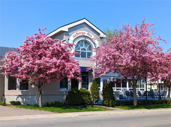 The front view of the Auberge des 21 hotel in the spring.