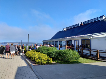 People lining up outside a restaurant called La Maison du Pêcheur.