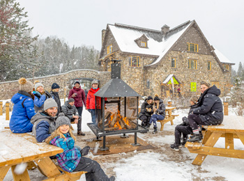 People gathered around the outdoor fireplace