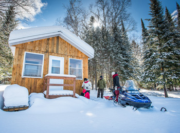 Chalet in winter with snowmobiler