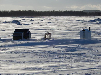 Ice fishing cabins on a frozen lake