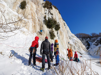 Group of climbers at the foot of an icy cliff